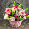 Pink basket of mixed flowers with lilies, roses, and carnations