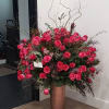 Large arrangement of pink roses in a tall copper vase
