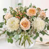 Peach roses and white chrysanthemums in a clear glass vase