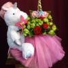 Plush unicorn holding a bouquet of red roses and green blooms