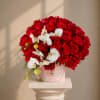 A lush dome of vivid red roses crowned with cascading white phalaenopsis