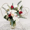 Bouquet of red and white flowers in a clear glass vase