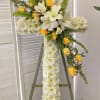 A cross on an easel that is mostly white with pops of