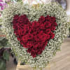 Heart-shaped red rose arrangement surrounded by white baby's breath