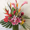 Tropical bouquet with pink lilies and red anthuriums in a glass vase