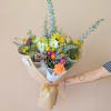 Hand-tied bouquet with sunflowers and mixed blooms in kraft paper