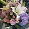 Designed in a modern glass cube with lilies, hydrangea, roses, spray roses