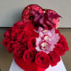 Red roses with pink orchids in a heart-shaped box