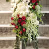 Tall standing floral spray with white lilies and red roses