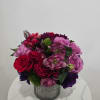Mixed pink, red, and purple bouquet in a silver vase