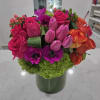 Bright mixed bouquet in a green vase with pink, purple, and orange flowers
