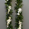 White flower lei with dense green leaves on a gray background