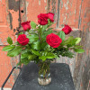 Red roses arranged in a clear glass vase