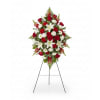 Standing floral spray with red roses, white lilies, and white daisies on an easel
