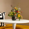 Mixed bouquet in a dark vase on a white table