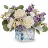 White roses and purple daisies in a square glass vase