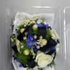 Small bouquet with white and blue flowers in a clear plastic box