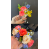 Small hand-held corsage with coral, cream, and blue flowers