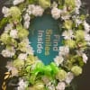 Green and white floral wreath with a bright ribbon bow