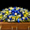 This casket make with blue roses, yellow lilies and white carnation 