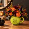 Halloween bouquet in a lime mug with orange and purple flowers