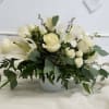 White roses and lilies arranged in a white vase