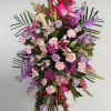Large standing floral spray with pink, purple, and white blooms on an easel