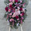 Standing floral spray with pink and white roses and lilies on an easel