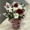 Bouquet of red roses and white daisies in heart-patterned wrap