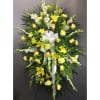 Yellow and white funeral spray with lilies, roses, and carnations