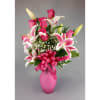 Pink roses and lilies arranged in a pink vase with a ribbon bow