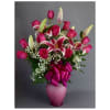 Pink roses and lilies in a pink vase with a ribbon