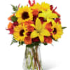 Sunflowers and orange roses in a clear glass vase