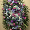 Large standing floral spray with pink and purple flowers and butterfly accents