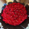 Large round bouquet of red roses wrapped in black paper