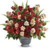 Red roses and carnations arranged in a gray urn vase