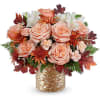 Peach roses and white flowers in a gold vase