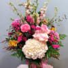 Mixed pink and cream bouquet in a glass vase with a pink ribbon