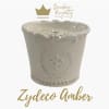 Cream ceramic candle jar with a scalloped rim and gold logo text