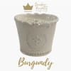 White decorative candle in a ceramic container with gold branding