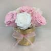 Small arrangement of pink and white roses in a gold vase with a pink ribbon bow