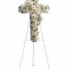 White floral cross arrangement on a stand with lilies and roses