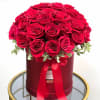 Red roses arranged in a round hat box with a ribbon