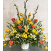 Yellow and orange rose arrangement in a white vase