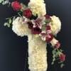 Cross-shaped floral tribute with red roses and white blooms