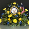 Yellow and blue floral tribute with a U.S. Navy emblem and American flag