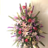 Large standing spray with pink lilies, red roses, and purple flowers
