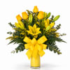 Yellow roses and lilies in a glass vase with a yellow bow