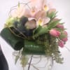 Pink anthuriums and tulips arranged in a clear glass vase