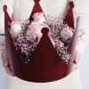 Pink roses in a burgundy crown-shaped bouquet holder